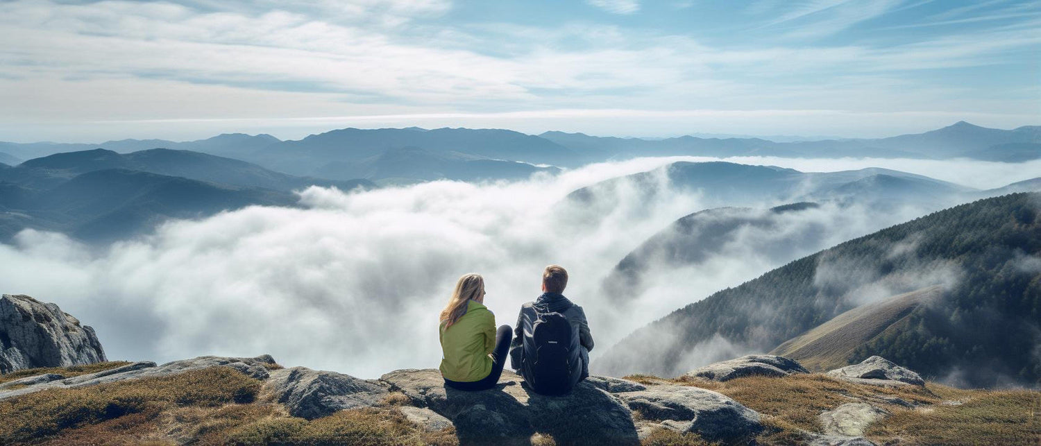 Man viewing out from mountain top looking over clouds